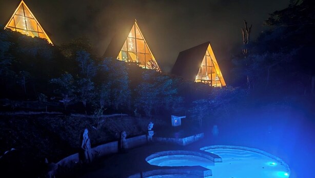 Un edificio con tetto a punta e zona piscina.