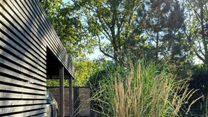 A cobblestone path leading to a wooden building with a car parked outside. - House with private jetty on Neversdorfer See (Leezen)