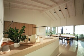 A modern kitchen with a large island, wooden cabinets, and a view to the outdoors. - Villa with infinity pool overlooking Lake Garda (Bardolino)