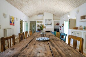 Ein rustikaler Essbereich mit einem Holztisch, Stühlen und einem Blumenstrauß.