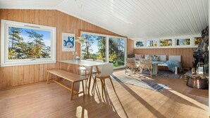 Un interior de madera con comedor, asientos y chimenea.