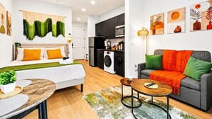 A modern apartment with a living room, a dining area, a kitchen, and a laundry area. - Bishop Arts Getaway | Yoga, Gym & Entertainment (Dallas)