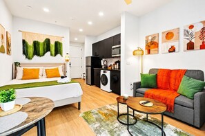 A modern apartment with a living room, a dining area, a kitchen, and a laundry area. - Bishop Arts Getaway | Yoga, Gym & Entertainment (Dallas)