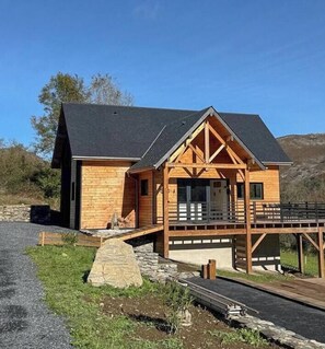 A wooden cabin with a porch, a stone foundation, and a clear sky. - Gorgeous wooden chalet near Lourdes (Ségus)