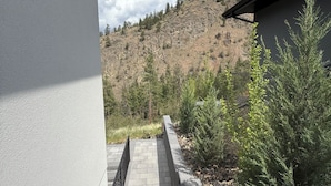 Un camino que lleva a un edificio con vistas a un paisaje montañoso.