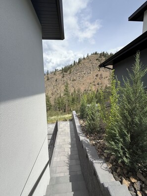 Ein Weg führt zu einem Gebäude mit Blick auf eine gebirgige Landschaft.