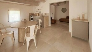 A kitchen with a dining area, a round table, and chairs. - Tuscan apartment with panoramic terrace (Montescudaio)