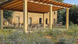 A covered outdoor seating area with stone walls and a tiled roof. - Tuscan apartment with panoramic terrace (Montescudaio)