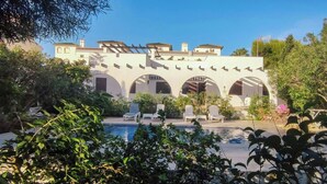 A building with arched windows and a swimming pool. - Ibizan design villa in Costa Blanca with pool (Torrevieja)