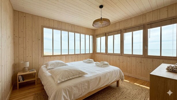 Ein Zimmer mit Holzboden, einem Bett, einem Nachttisch und einem Schreibtisch.