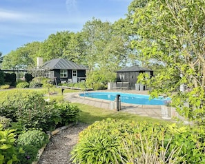 A backyard with a swimming pool, a small shed, and a house with a dark roof. - Relax in the countryside with pool (Aulum)