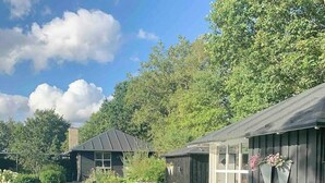 A backyard with a swimming pool, a hot tub, and a wooden deck. - Relax in the countryside with pool (Aulum)