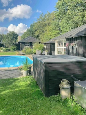 A backyard with a swimming pool, a hot tub, and a wooden deck. - Relax in the countryside with pool (Aulum)