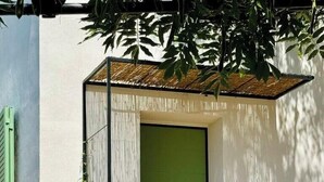 Ein modernes Gebäude mit einer grünen Tür, einer kleinen Veranda und Stufen, die zum Eingang führen.