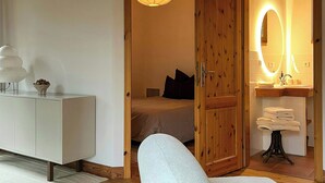 Ein Schlafzimmer mit einem Bett, einem Nachttisch, einer Lampe und einem Holzschrank.
