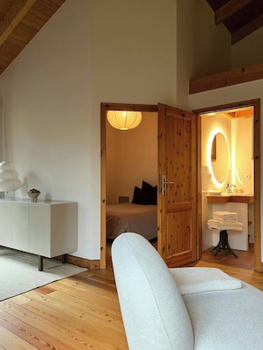 Un dormitorio con cama, mesita de noche, lámpara y un armario de madera.