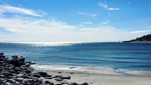 A beach with a rocky shoreline and a clear blue sky.