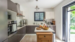 Een moderne keuken met inbouwapparatuur, een centraal eiland en een groot raam.