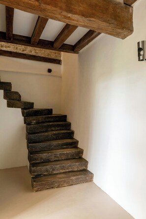 Eine hölzerne Treppe im rustikalen Stil, die zu einer Empore führt.