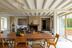 Ein Essbereich mit Holztisch, Stühlen und Kamin.
