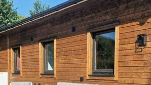 A wooden cabin with a deck, outdoor seating, and large windows. - Charming seaside cabin in Tingvoll (Tingvoll)