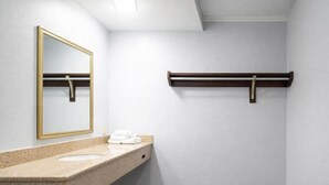 A bathroom with a granite countertop, a mirror with a gold frame, and a towel rack. - KS-King Smoking, Comfort Room, One king Bed, (Antioch)