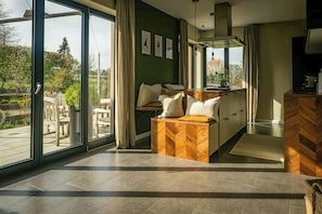 Eine moderne Küche mit Holzarbeitsplatte, einem eingebauten Backofen und einem großen Fenster mit Blick auf einen Garten.