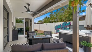 Eine Terrasse im Freien mit Deckenventilator, Whirlpool und einem Schild mit dem Aufdruck 'Write Your Story'.