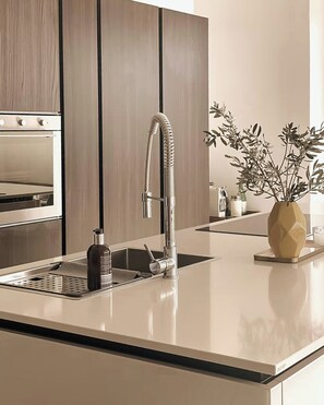 Eine moderne Küche mit Einbauofen, Edelstahlarmatur und minimalistischem Design.