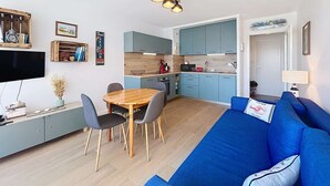 A compact living space with a dining area, kitchenette, and a blue sofa. - QUIBERON - 2 rooms - 33m2 - City center (QUIBERON)