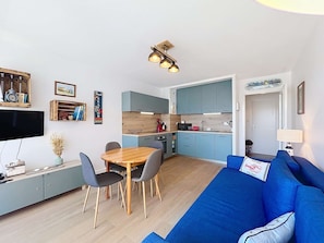 A compact living space with a dining area, kitchenette, and a blue sofa. - QUIBERON - 2 rooms - 33m2 - City center (QUIBERON)