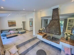 Ein modernes Wohnzimmer mit einer Couch, einem Couchtisch, einem Kamin und einer Treppe zu einer weiteren Ebene.