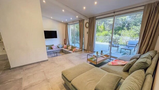 Un salon moderne avec un canapé, une table basse et un téléviseur fixé au mur.