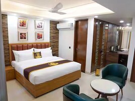 Una habitación de hotel con cama, escritorio, silla y ventilador de techo.
