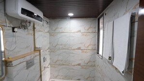 A bathroom with marble walls, a shower, and a window. - Five Palms Hotels (Gurugram)