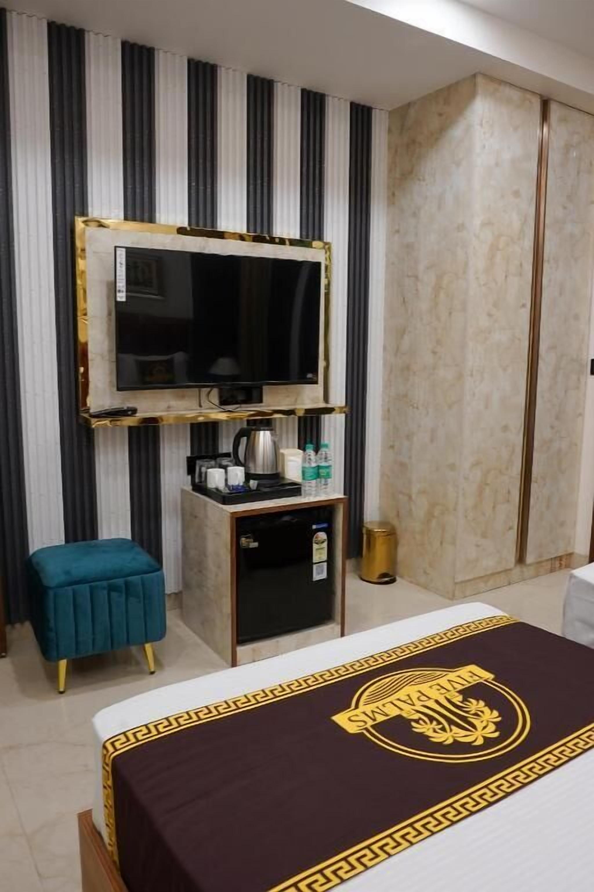 Une chambre d’hôtel équipée d’un lit, d’une télévision, d’un petit bureau avec une machine à café et d’un mini-bar.