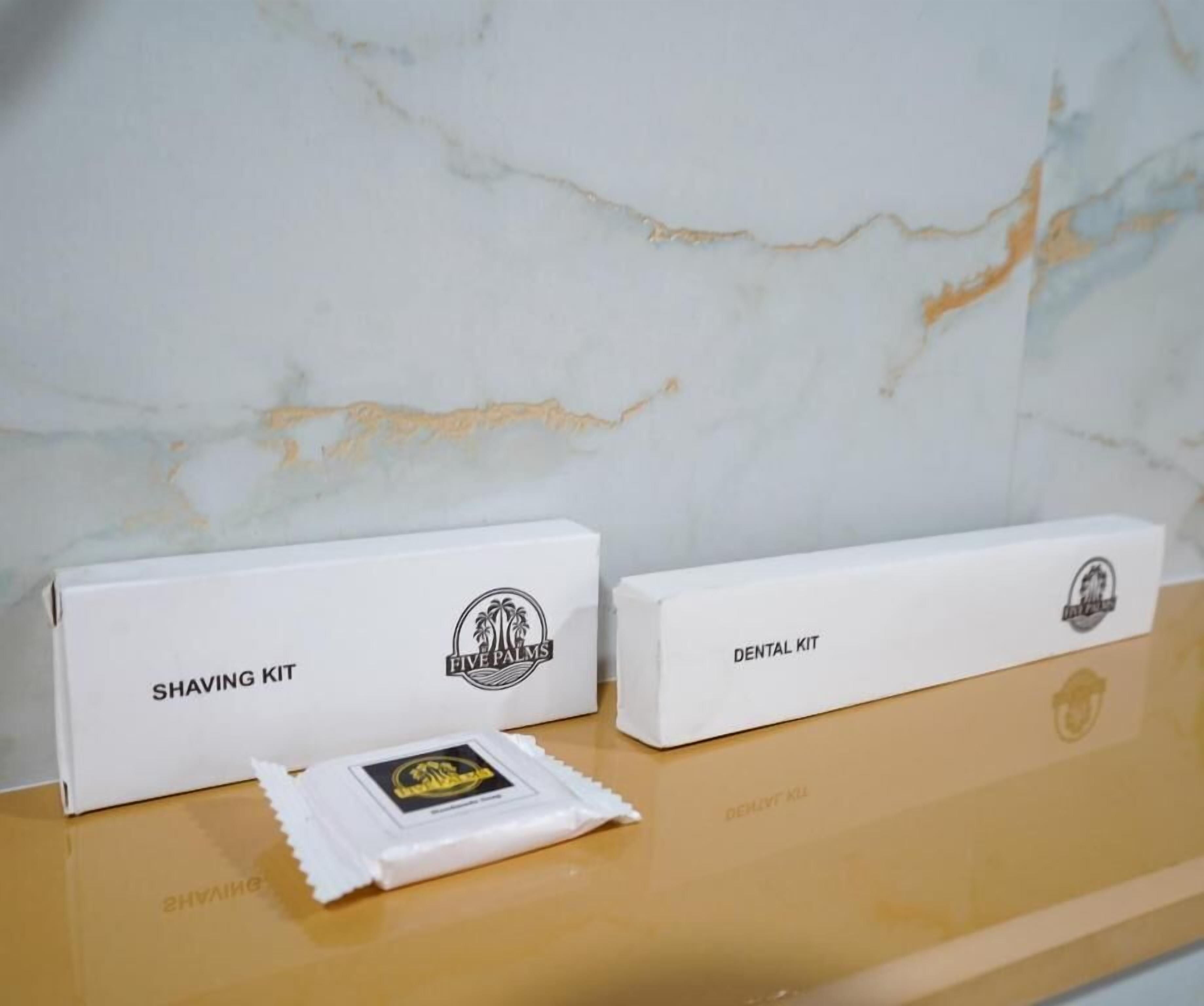 Two white boxes labeled 'Shaving Kit' and 'Dental Kit' on a marble surface.