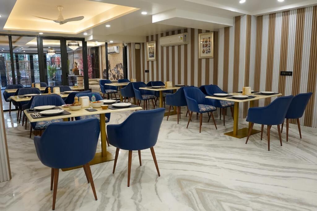 A restaurant with marble flooring, blue chairs, and striped wallpaper.