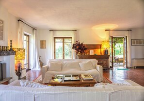Ein geräumiges Wohnzimmer mit Sofa, Couchtisch und Blick zur Küche.