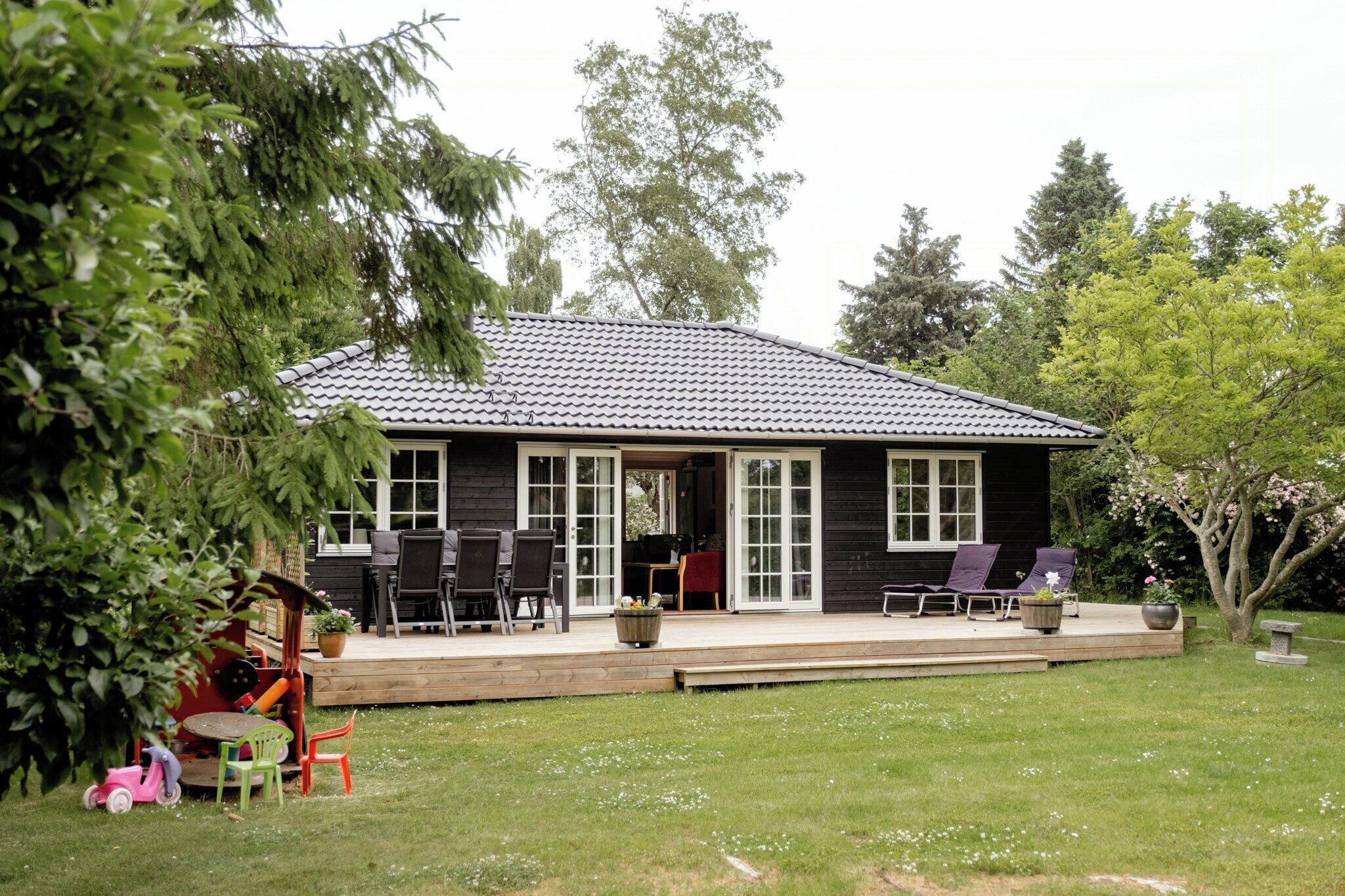 A house with a patio, outdoor seating, and a garden.