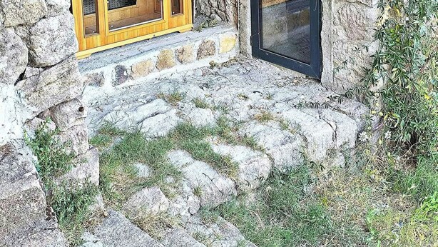 A stone building with a wooden door and window, surrounded by greenery. - Charming renovated workshop in Ardèche (Joyeuse)