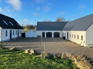 A building with a gravel driveway, multiple garage doors, and a sloped roof.