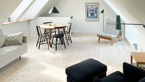 Un loft moderne comprenant un coin repas, un canapé et un escalier.