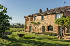 A rustic stone building with arched windows and a well-maintained lawn. - Historic farmhouse with loggia in Cortona (Cortona)