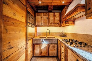 Eine Holz-Küche mit Spüle, Herd und Schränken.