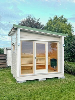 Een laag, eenlaags gebouw met een groen dak, grote glasramen en een houten interieur.