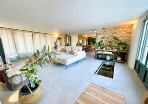 Ein modernes Wohnzimmer mit einer Couch, einem Couchtisch und Topfpflanzen.