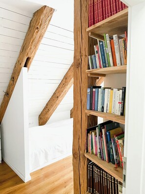 A wooden staircase with bookshelves on either side. - Holiday home in rural idyll of the Uckermark (Weggun)
