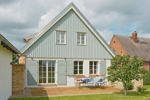 A house with a gabled roof, large windows, and a patio with outdoor furniture. - Holiday home in rural idyll of the Uckermark (Weggun)