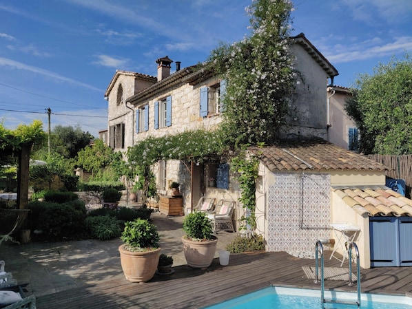 A stone building with a pool, potted plants, and outdoor furniture. - Provençal apartment near Saint-Paul de Vence (Roquefort-les-Pins)